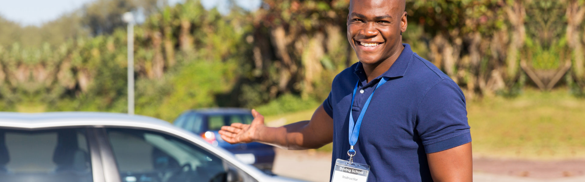 Driver instructor smiling while showing his car